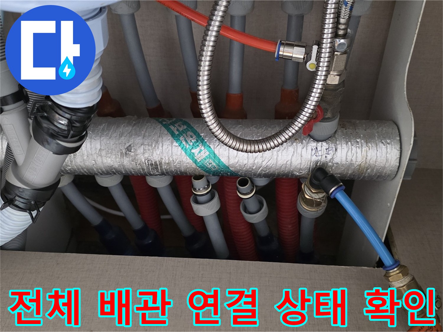 난방 분배기 전체적인 배관 연결 상태를 꼼꼼하게 확인하고 있습니다 - 작은 틈새도 놓치지 않으려고 집중하고 있어요