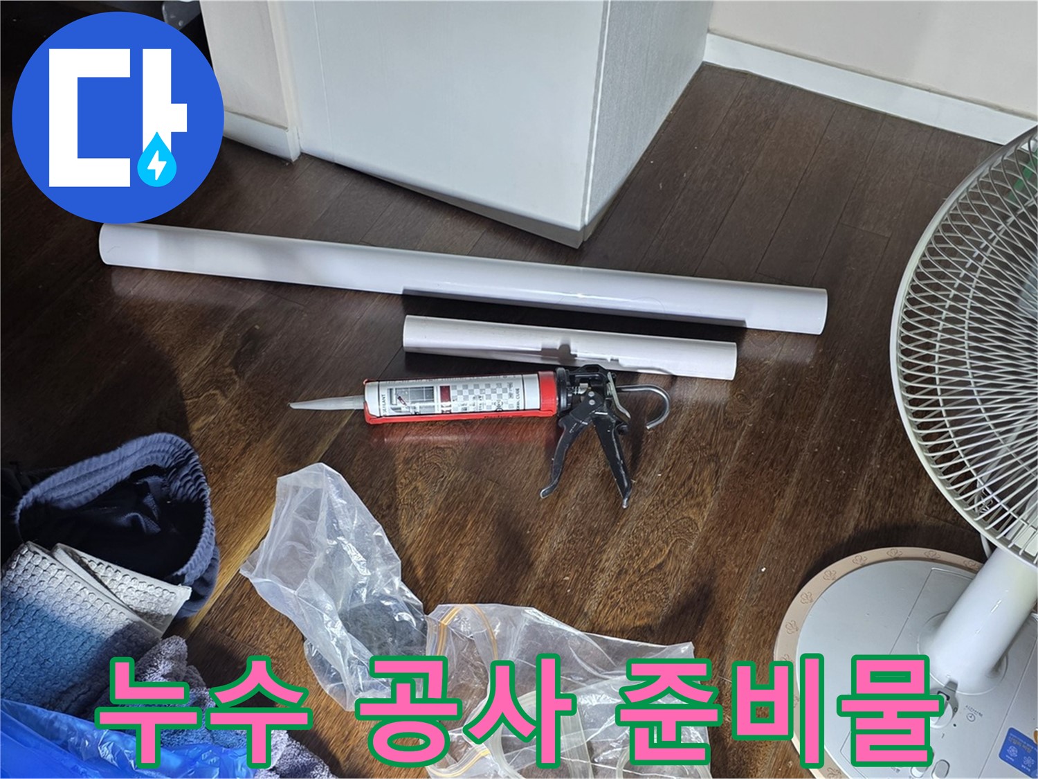 누수 공사를 위한 준비물 - 실리콘과 배관 자재, 그리고 공구들이 가지런히 놓여 있습니다.