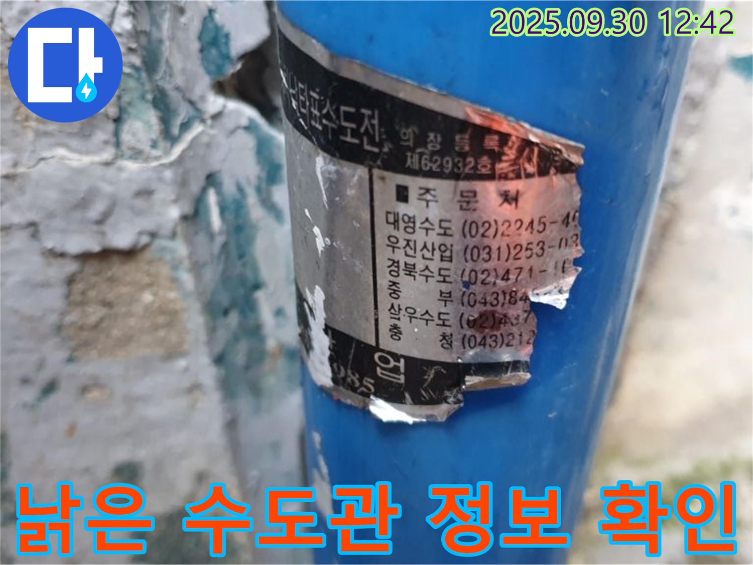 오래된 수도관에 붙은 스티커 - 시공 업체 정보와 연락처가 희미하게 남아있습니다.