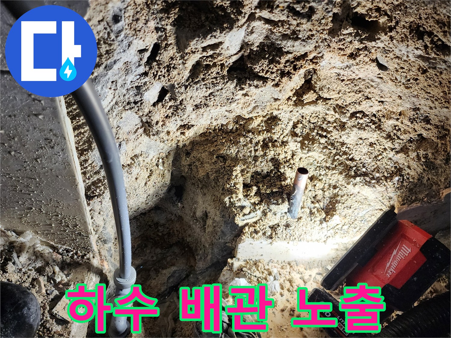 흙과 파편 속에 드러난 하수 배층 배관