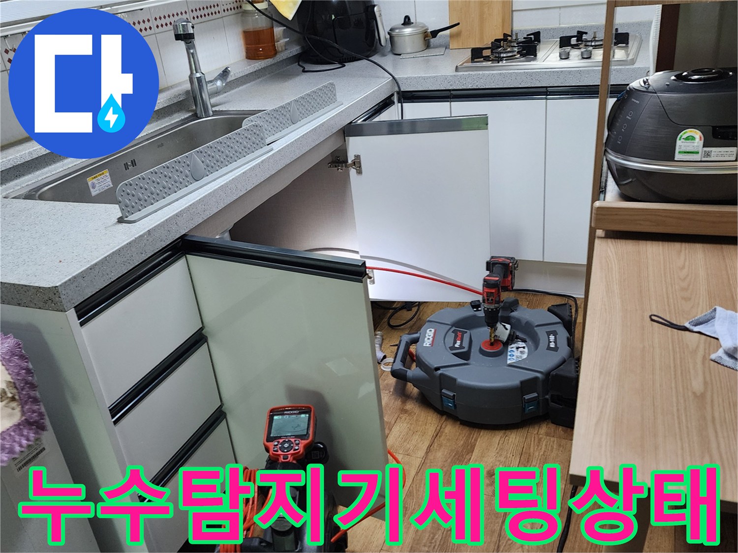 싱크대 하단 작업 공간에 배치된-정밀 누수 탐지기와 점검용 장비들입니다.
