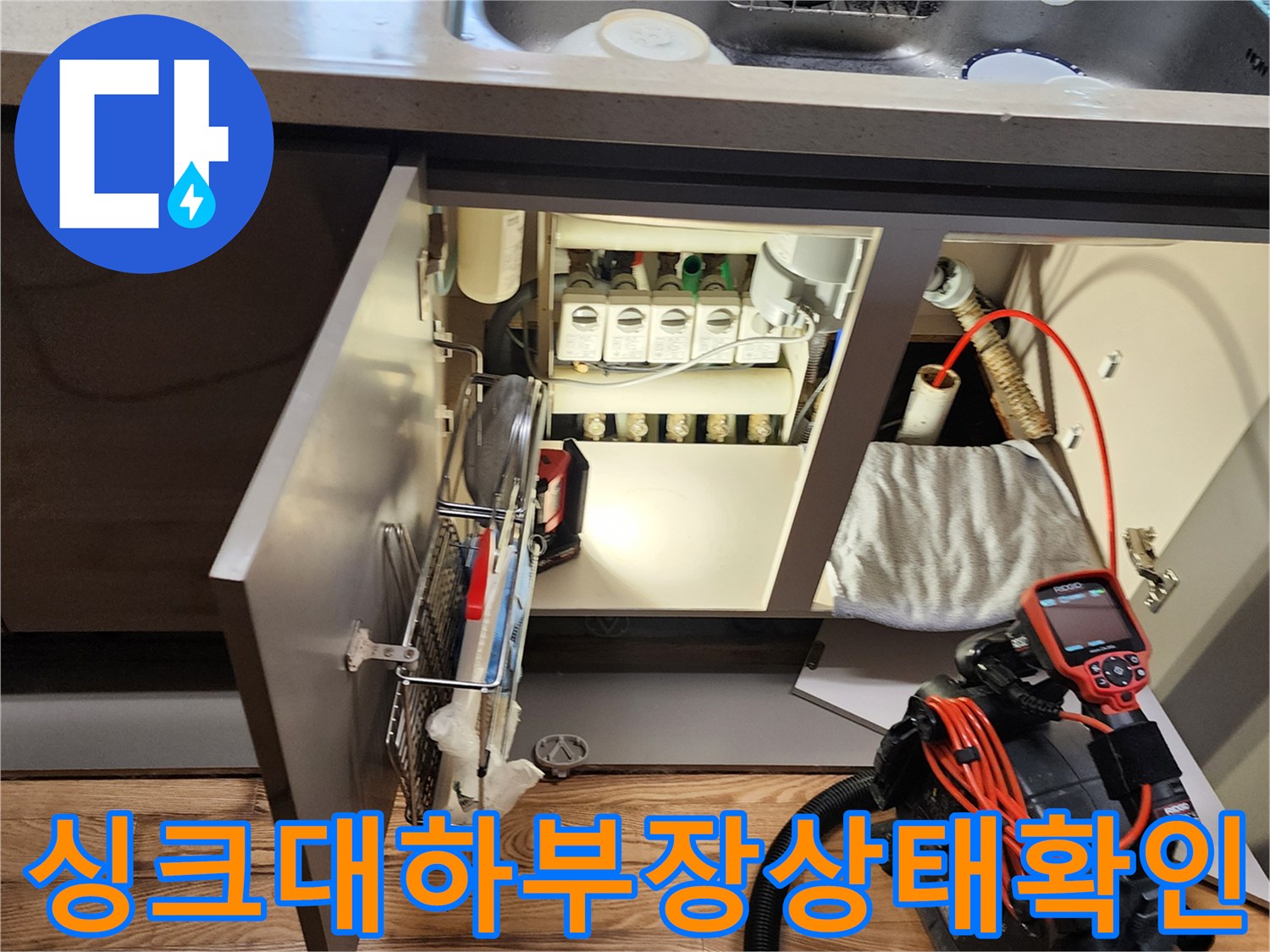 싱크대-하단-배관-연결부와-진단용-장비가-놓여있는-현장