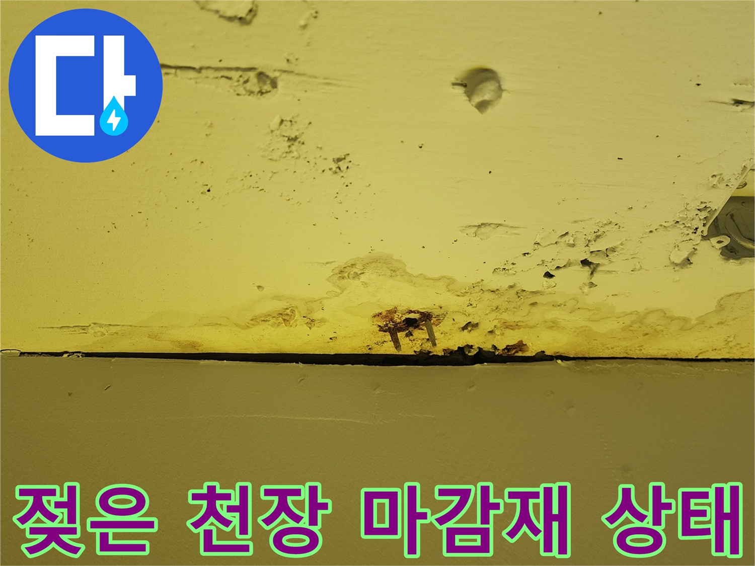 누수 흔적이 남은 천장-습기로 인해 얼룩진 노란색 패널 부위