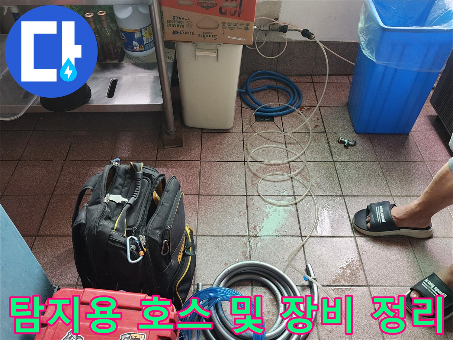 현장 바닥에 배치된 파란색과 회색의 긴 배관 호스들