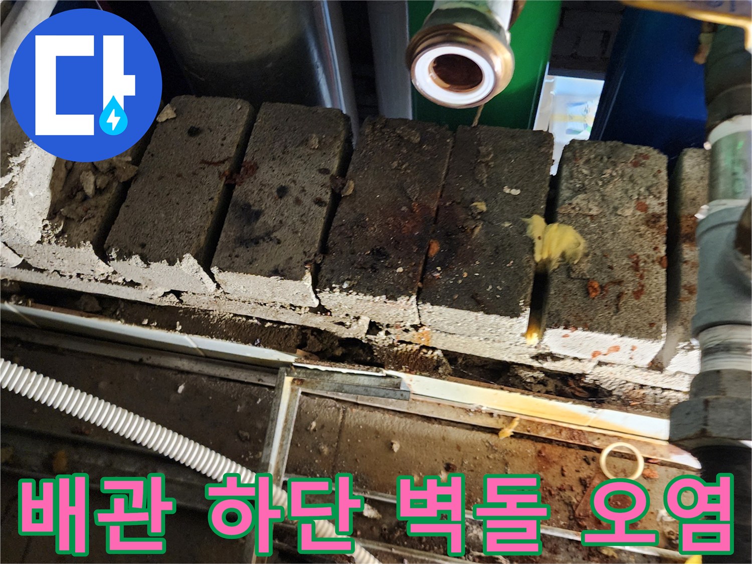 오염된 벽돌과 배관 연결 부위의 근접 촬영 사진입니다.