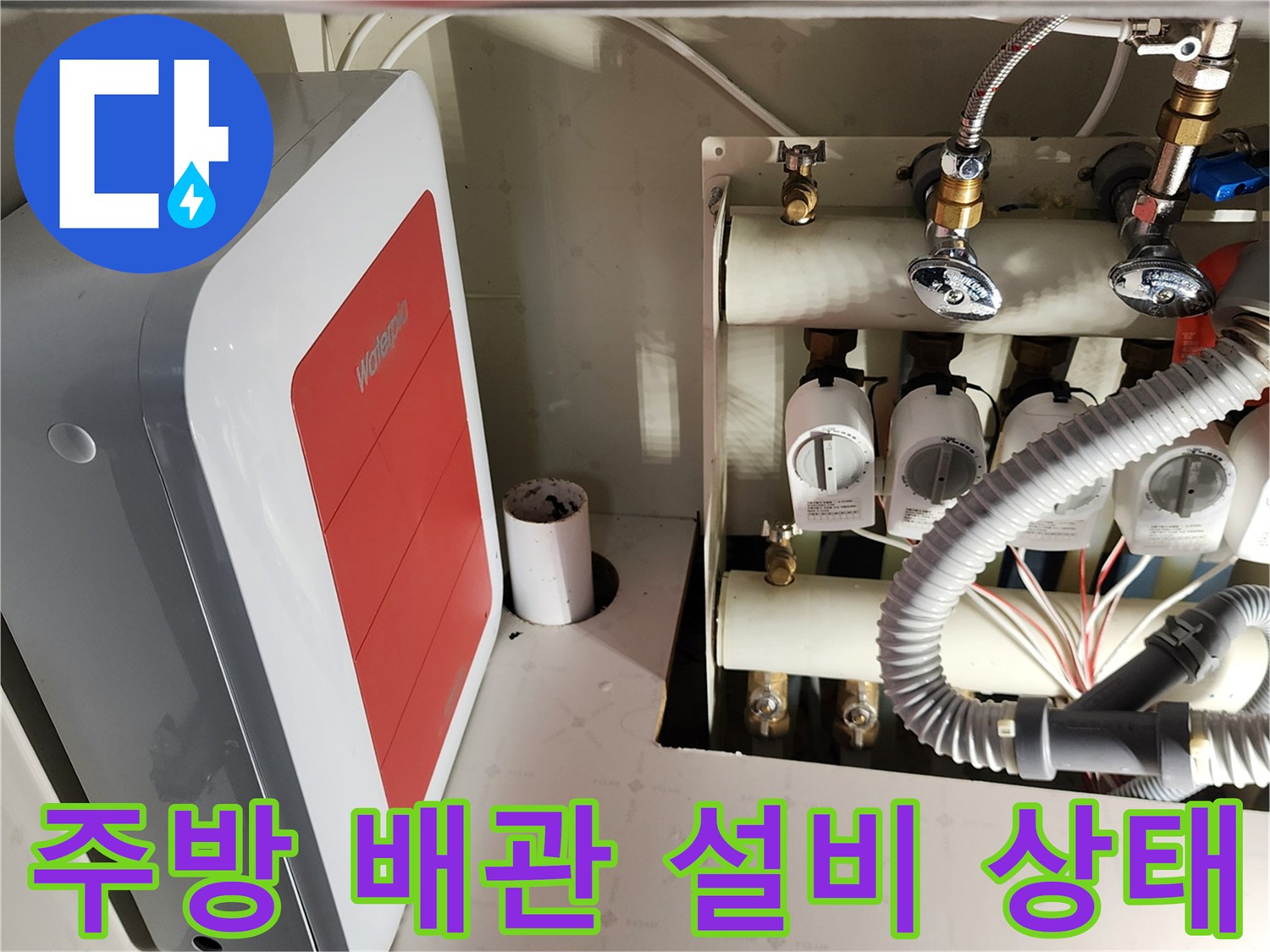 싱크대 하부장 내부의 수도 밸브와 급수 배관 연결 부위 모습입니다.