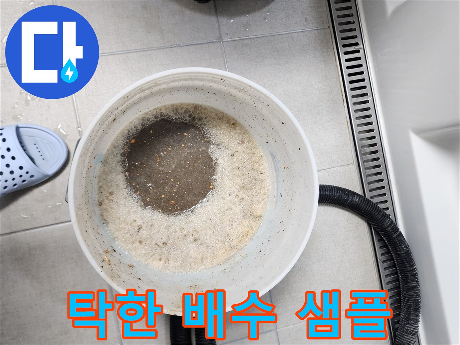 양동이에 담긴 거품 섞인 탁한 물과 흡입 호스 장비