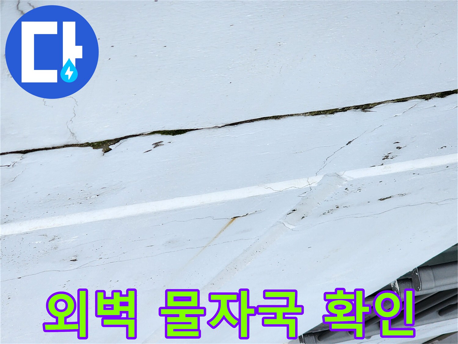하얀색 마감재 위로 나타난 균열과 습기 자국