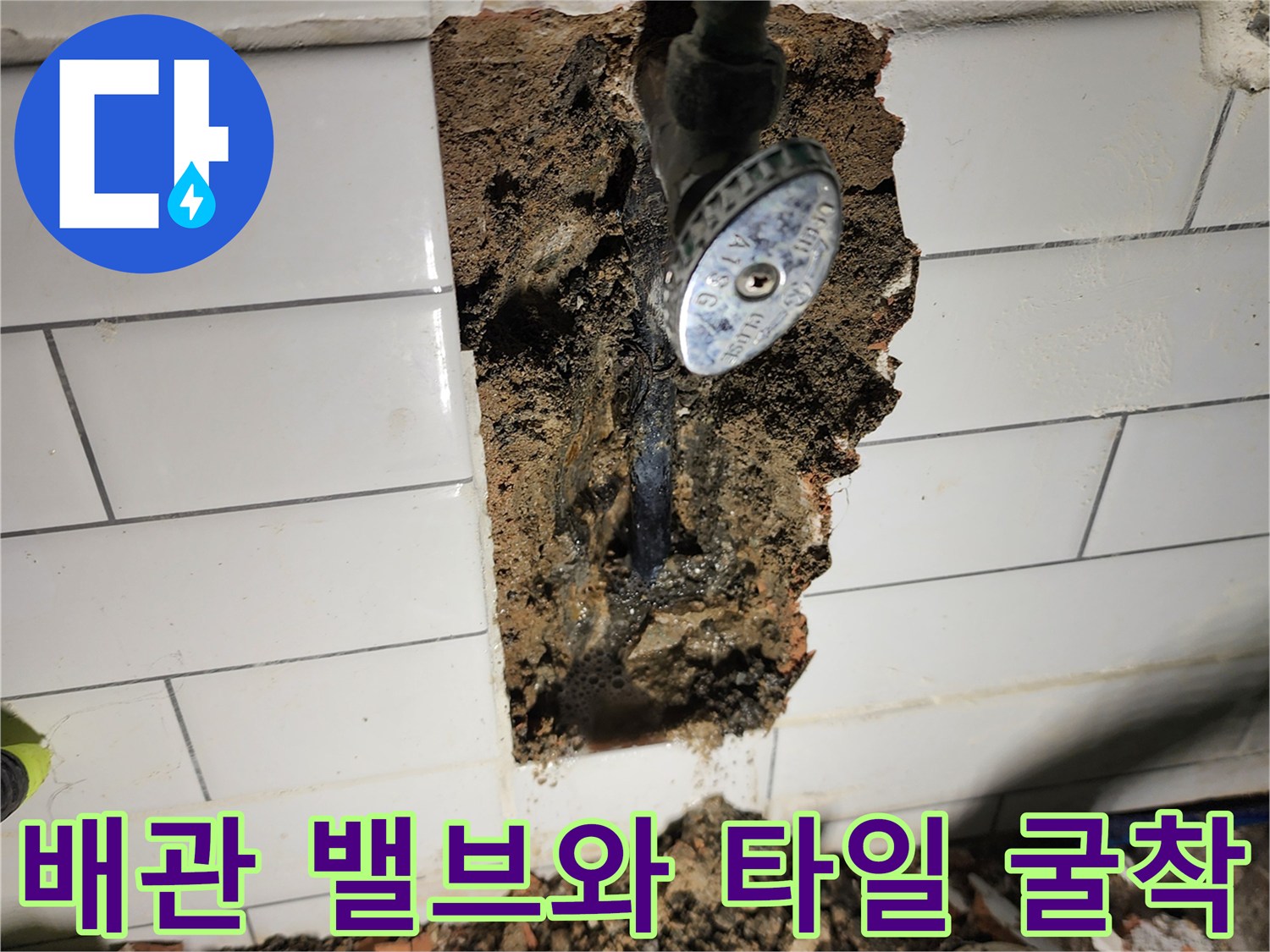 타일이 깨진 자리에 드러난 수도 밸브와 노후 배관