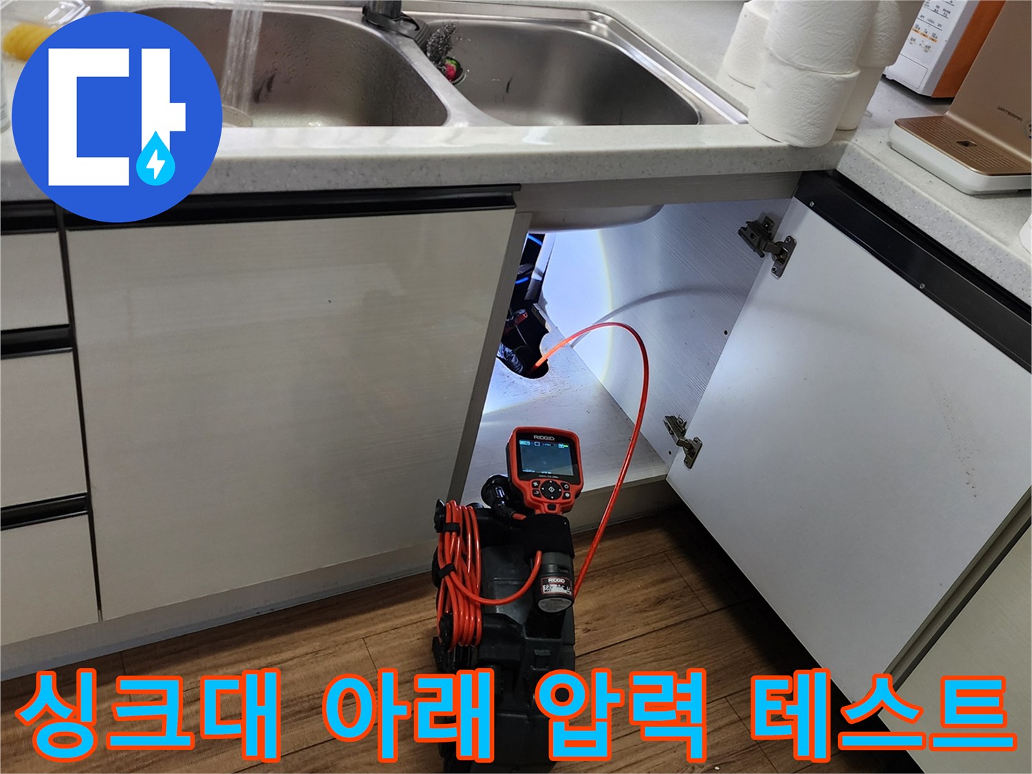 싱크대 하부장-디지털 압력 게이지를 활용한 배관 기밀 점검 중인 모습