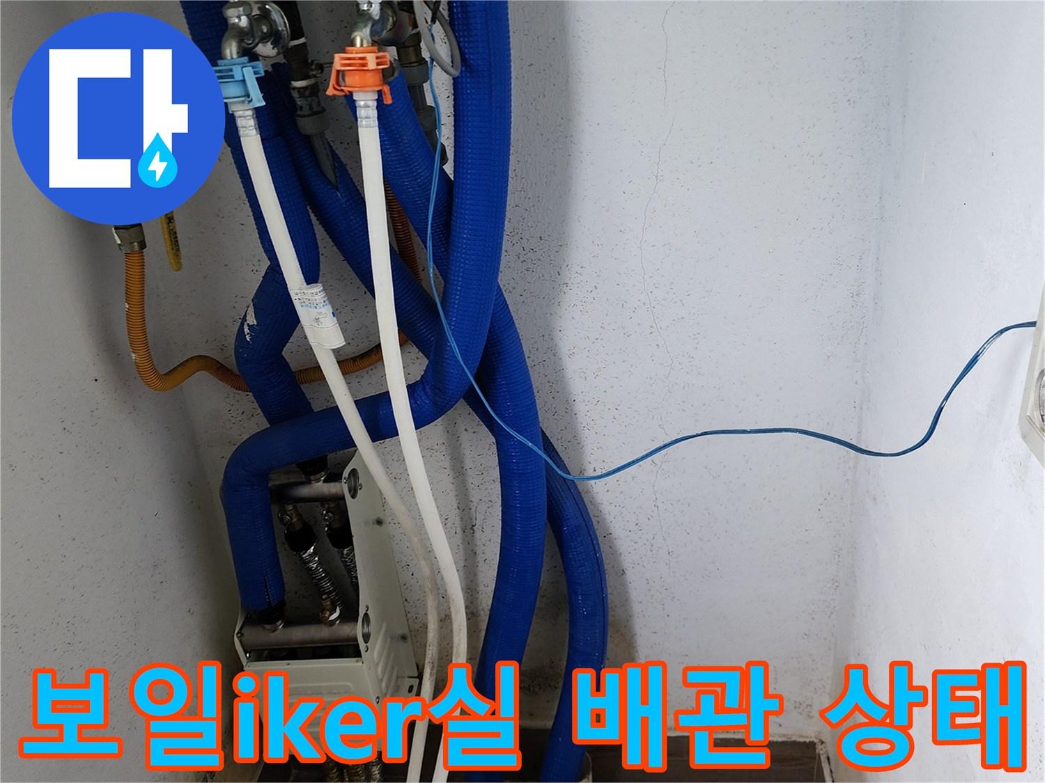 보일러 하부-파란색 주름관과 흰색 배관의 연결 부위 근접 촬영