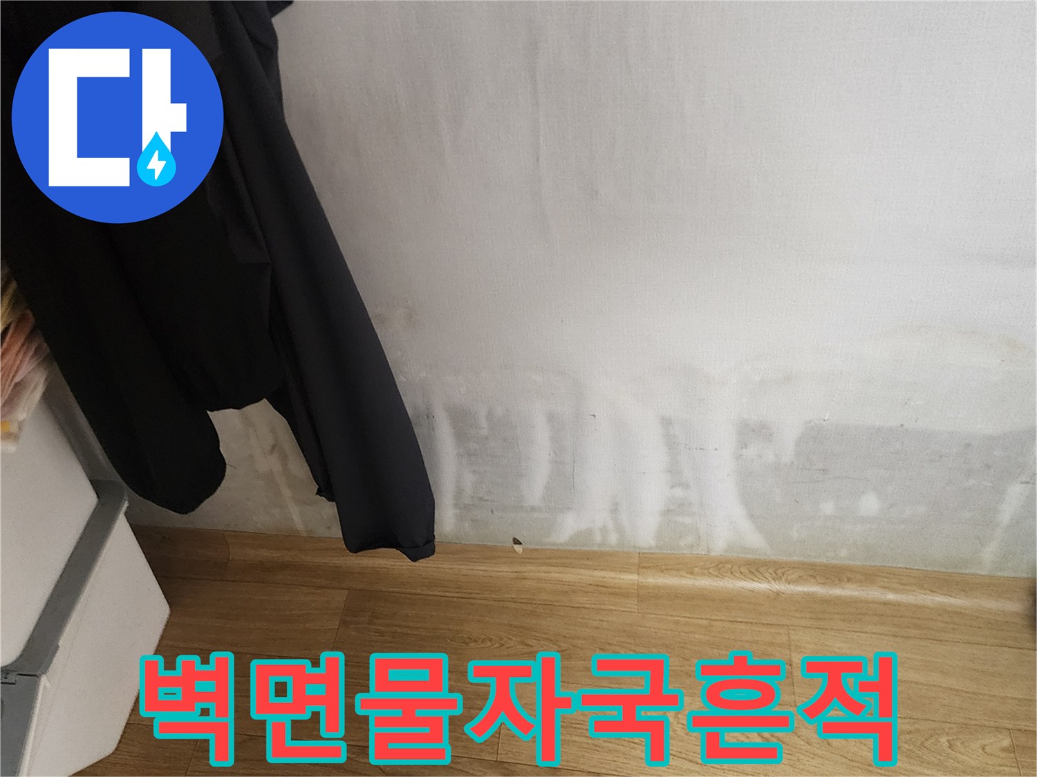 아파트 벽지 하단에 나타난 심한 물 얼룩과 변색 부위