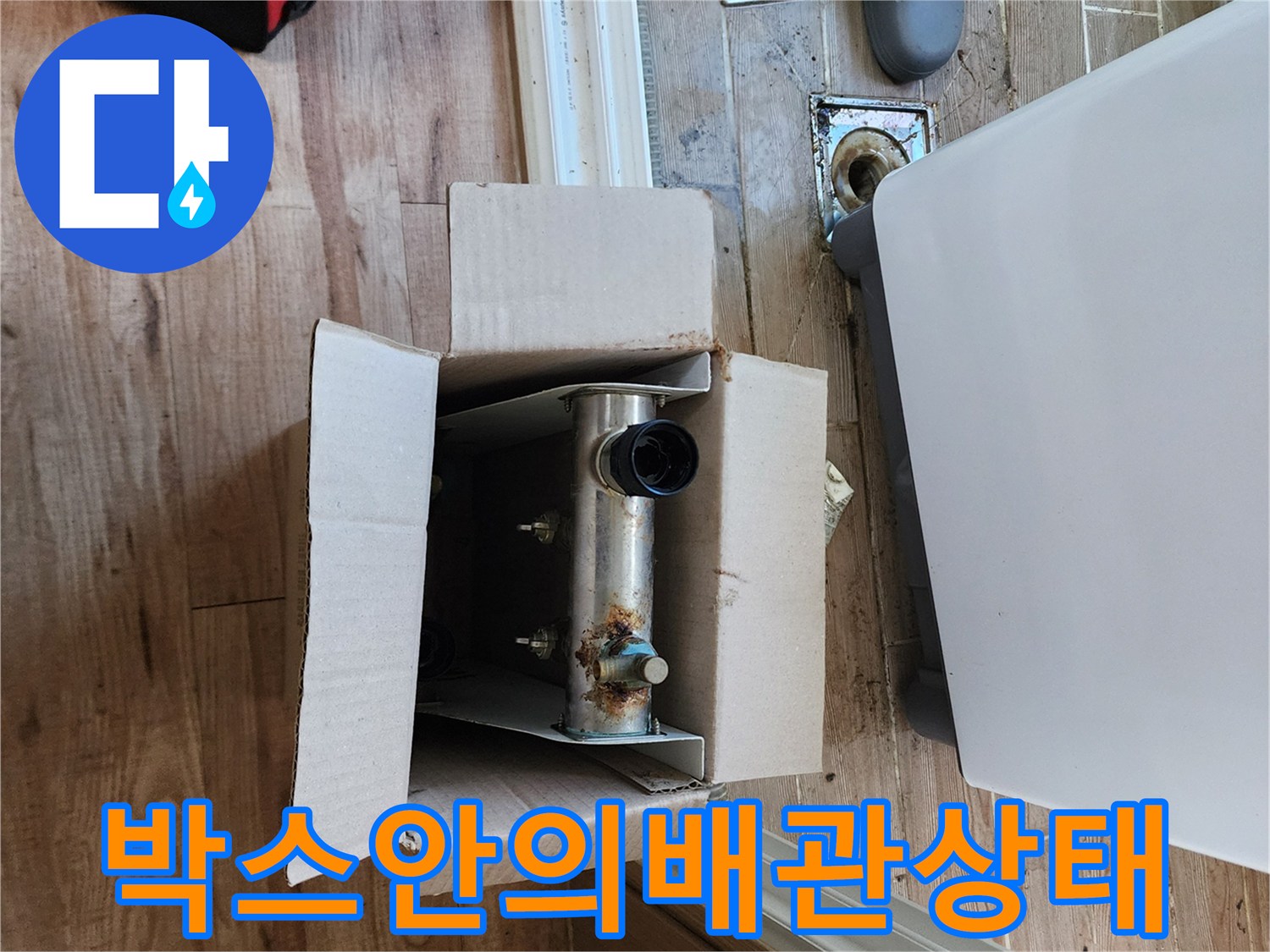 종이 박스 내부에 놓인 부식된 금속 배관과 연결 부위 모습