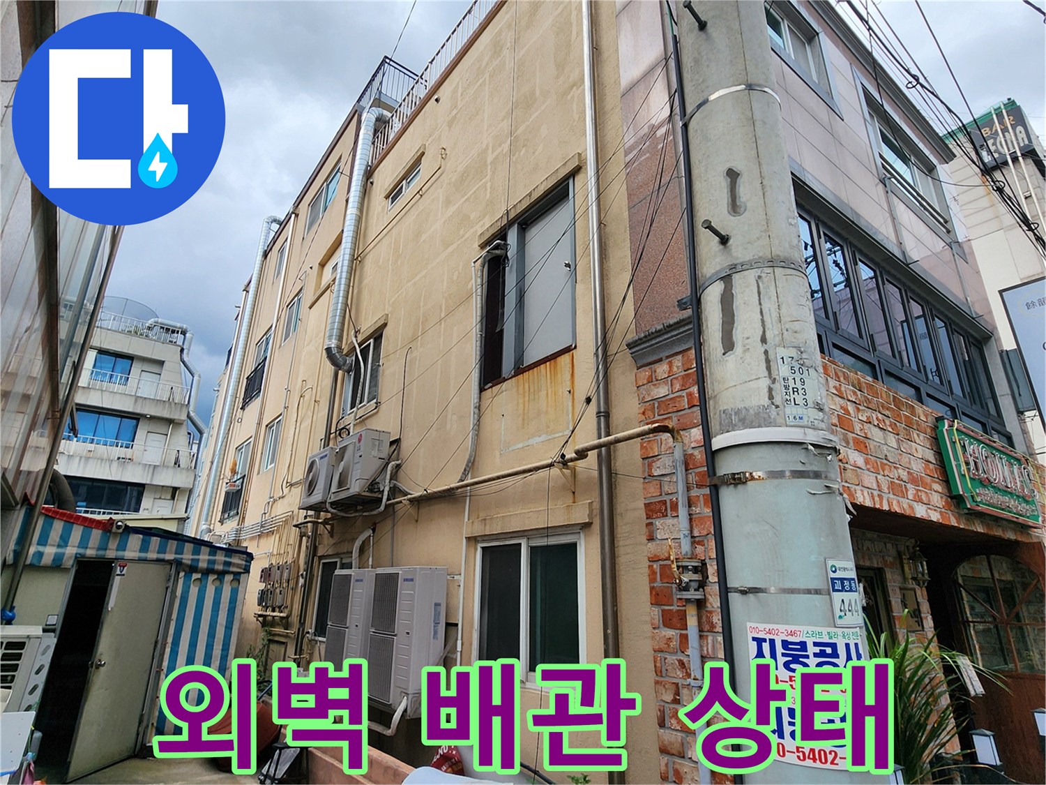 건물 외벽의 수직 배관과 벽면 마감재 근접 촬영