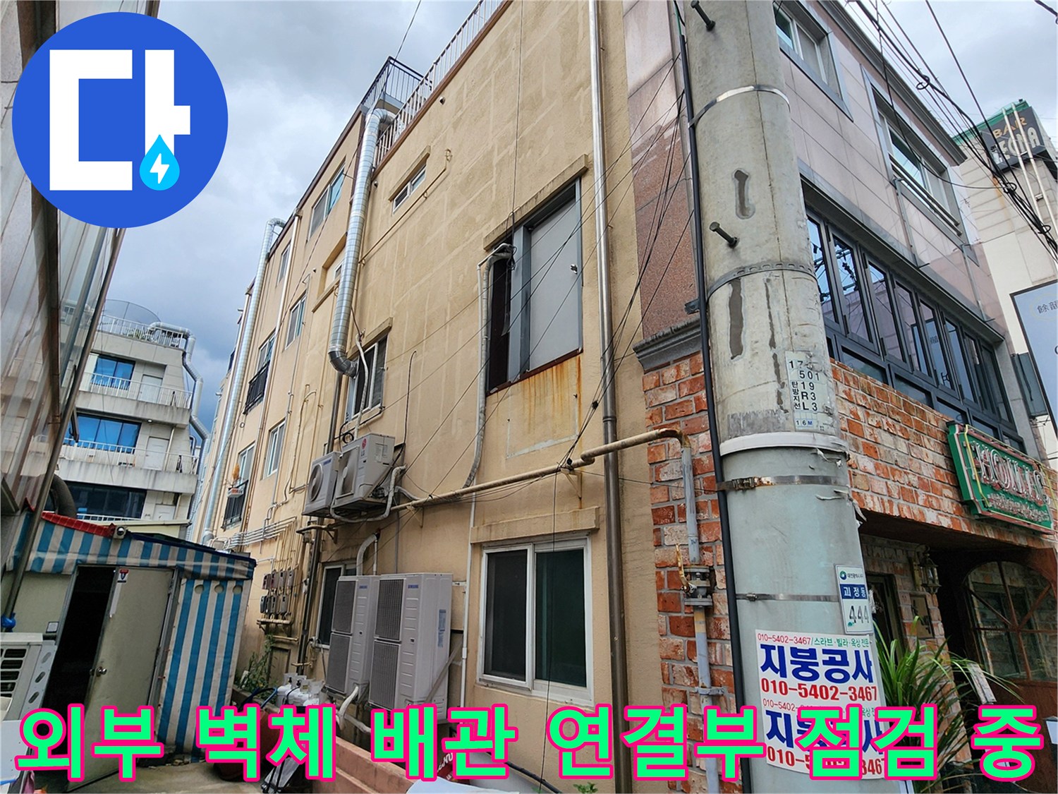 건물 외벽의 에어컨 배관과 외부로 돌출된 금속관의 설치 상태