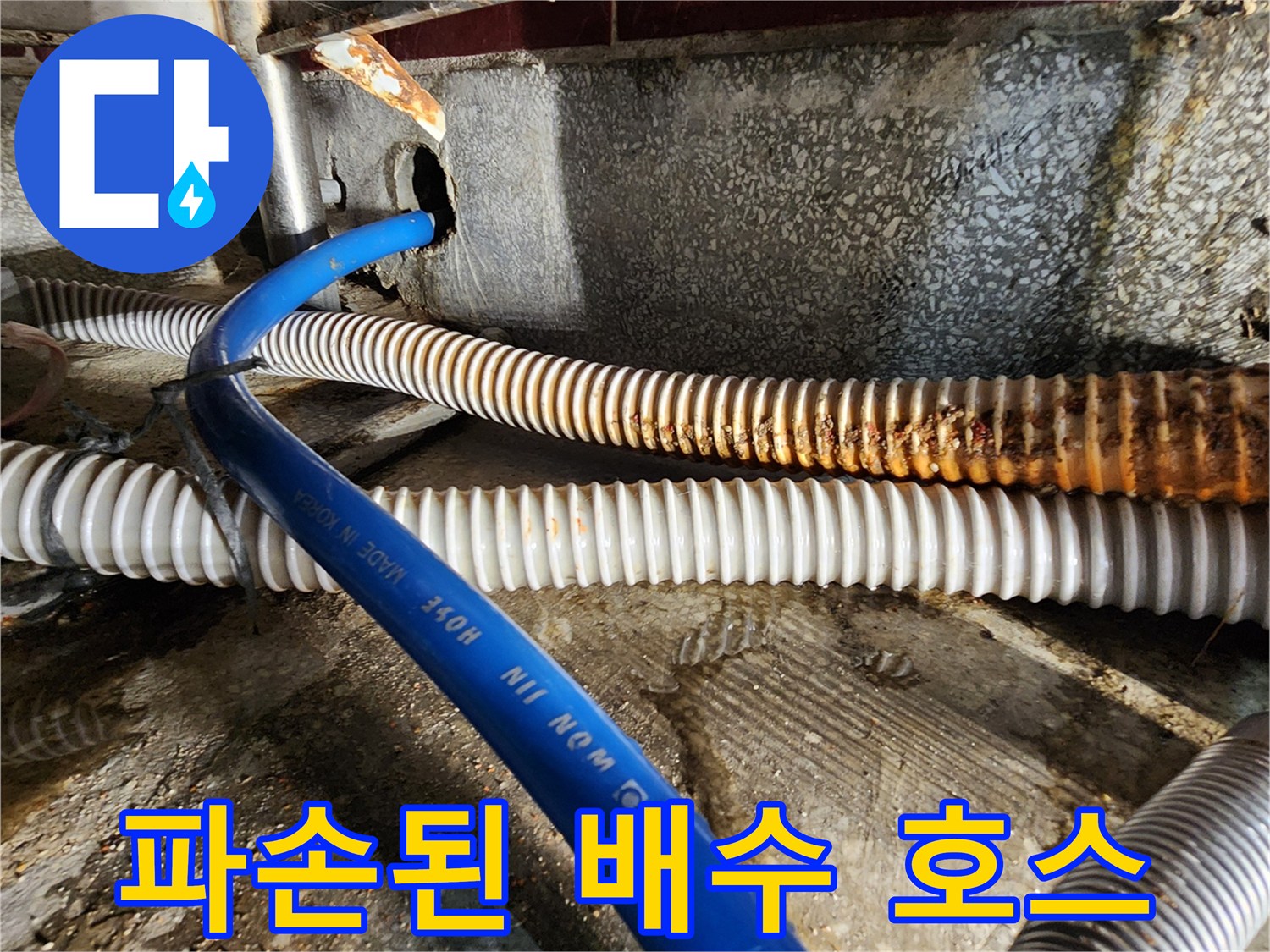 오염된 바닥면과 갈색으로 변색된 노후 배수 호스 상세 모습