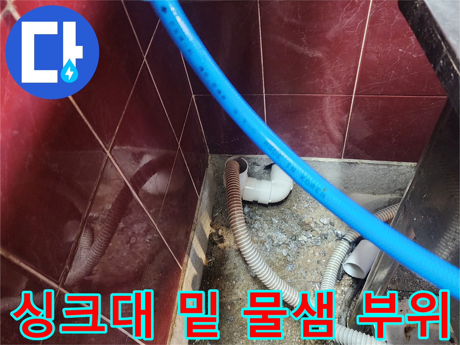 물기가 스며든 싱크대 하단 배관 및 벽면 타일 근접 사진