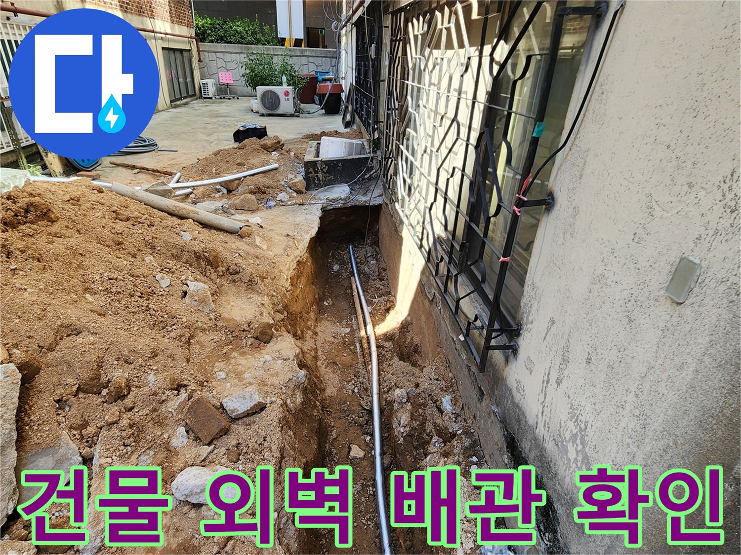 외벽 옆으로 길게 드러난 새 배관과 주변 흙더미
