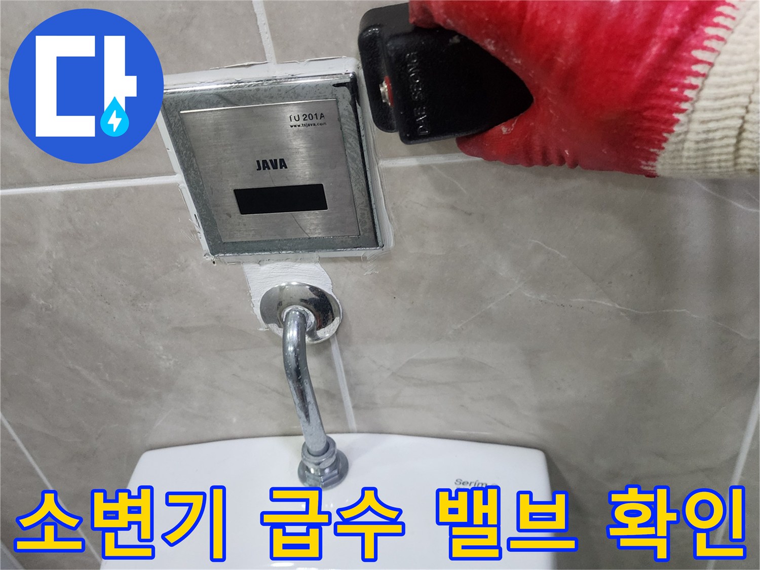 소변기에 연결된 금속 배관과 자동 밸브의 상태를 검사하는 모습입니다.
