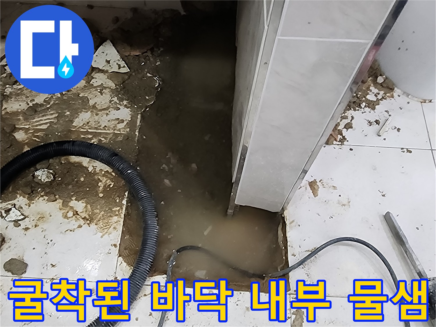 화장실 바닥 공사-배관 주변에 고여 있는 물과 작업용 호스