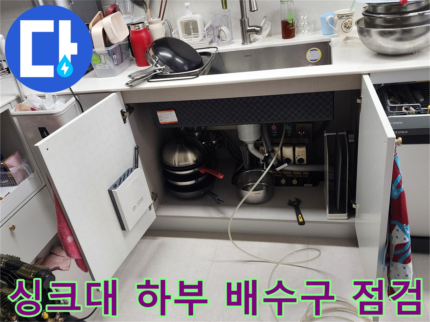 싱크대 내부 배관 연결 부위의 습기와 물샘 여부를 확인하는 모습