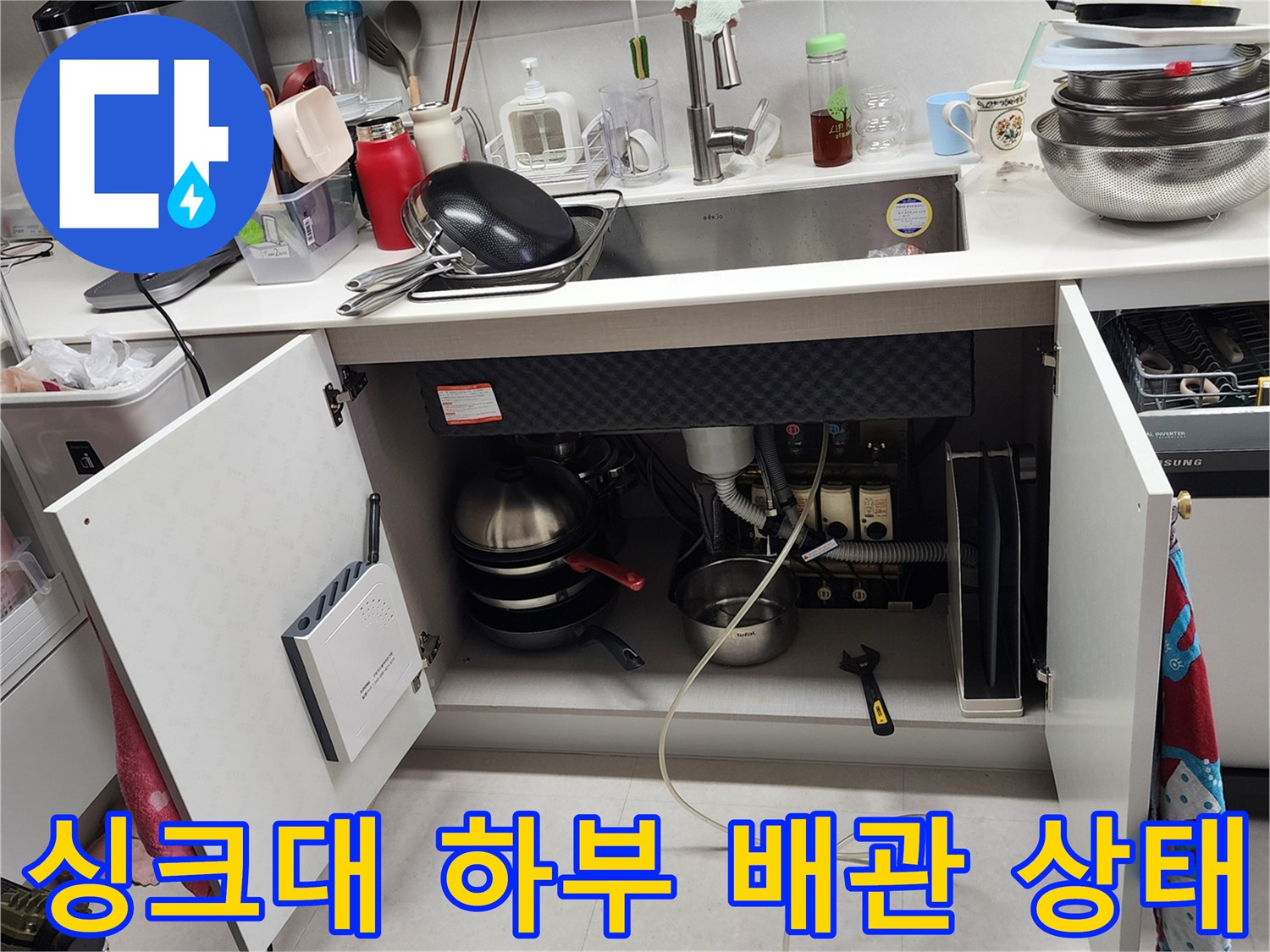 주방 싱크대 밑 하부장 내부의 노후된 배관 연결 부위 점검 상황