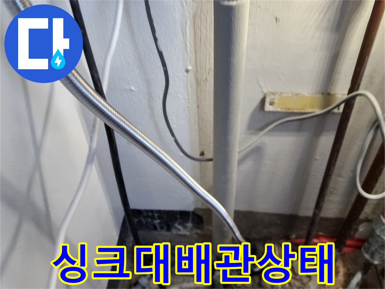 주방 싱크대 아래 은색 자재와 급수 배관의 배치 현황