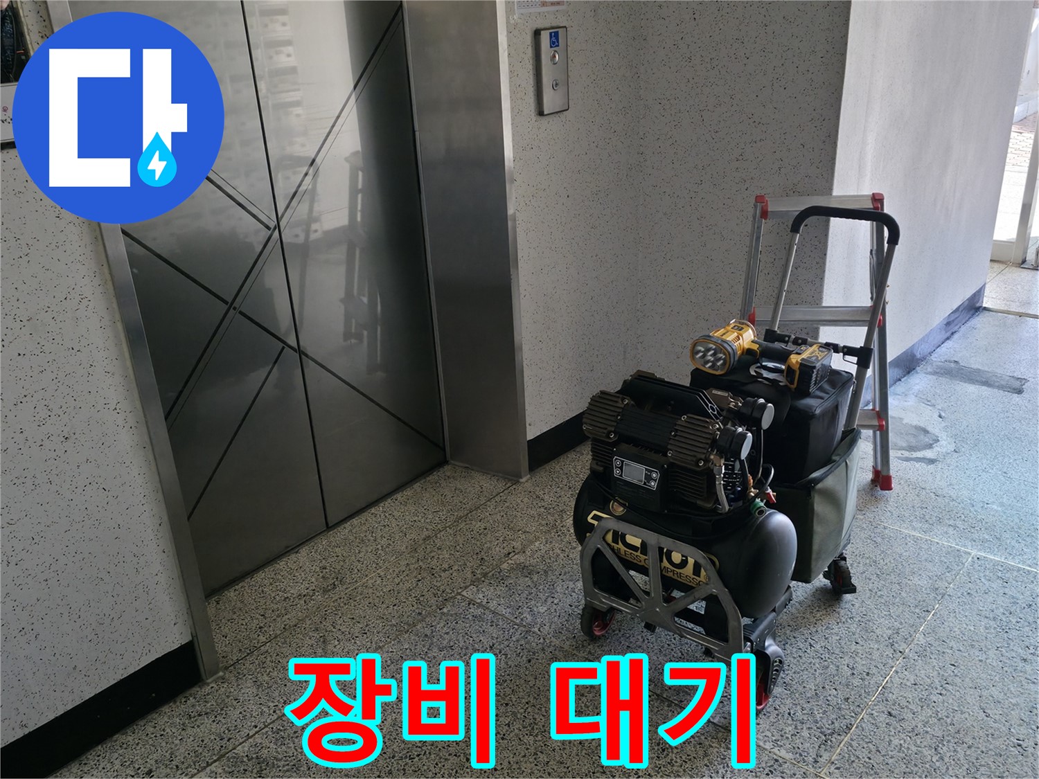 엘리베이터 앞 장비 대기 - 신속한 누수 해결을 위해 준비 중입니다.
