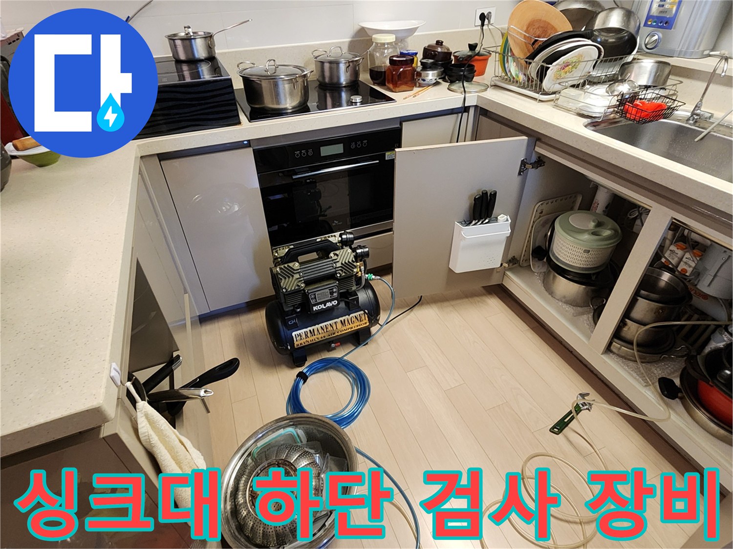 누수 진단을 위해 싱크대 밑에 설치된 콤프기 및 연결 호스