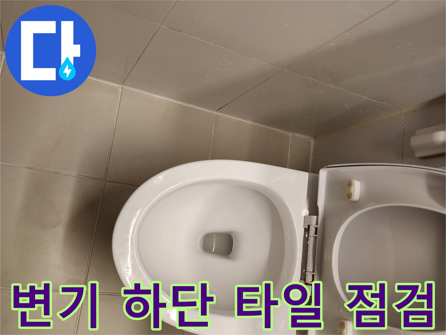 양변기 주변의 젖은 타일 표면을 근접 촬영한 사진입니다.