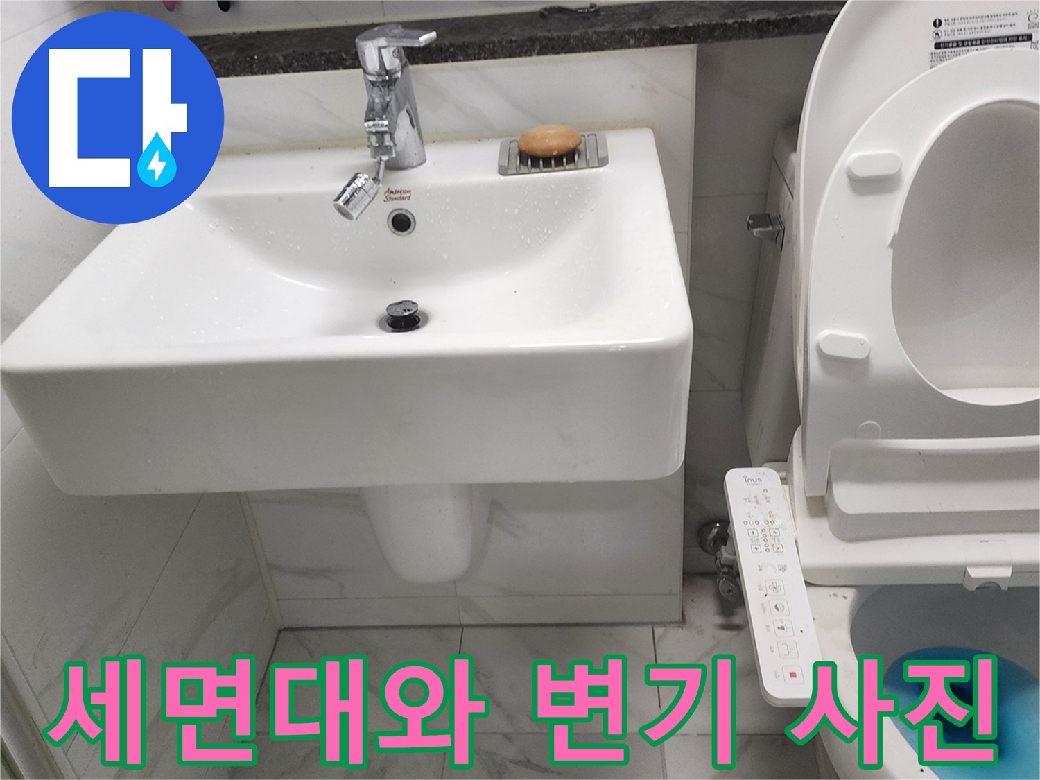 하얀색 세면대 수전과 비데가 설치된 화장실 내부 모습입니다.