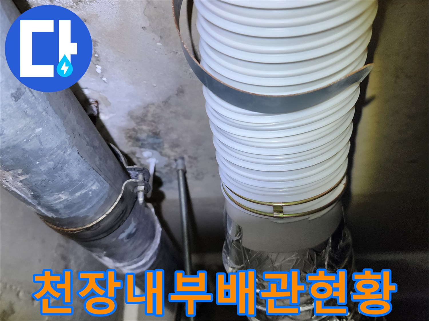 하얀색 주름관과 은색 배관이 설치된 천장 내부 모습