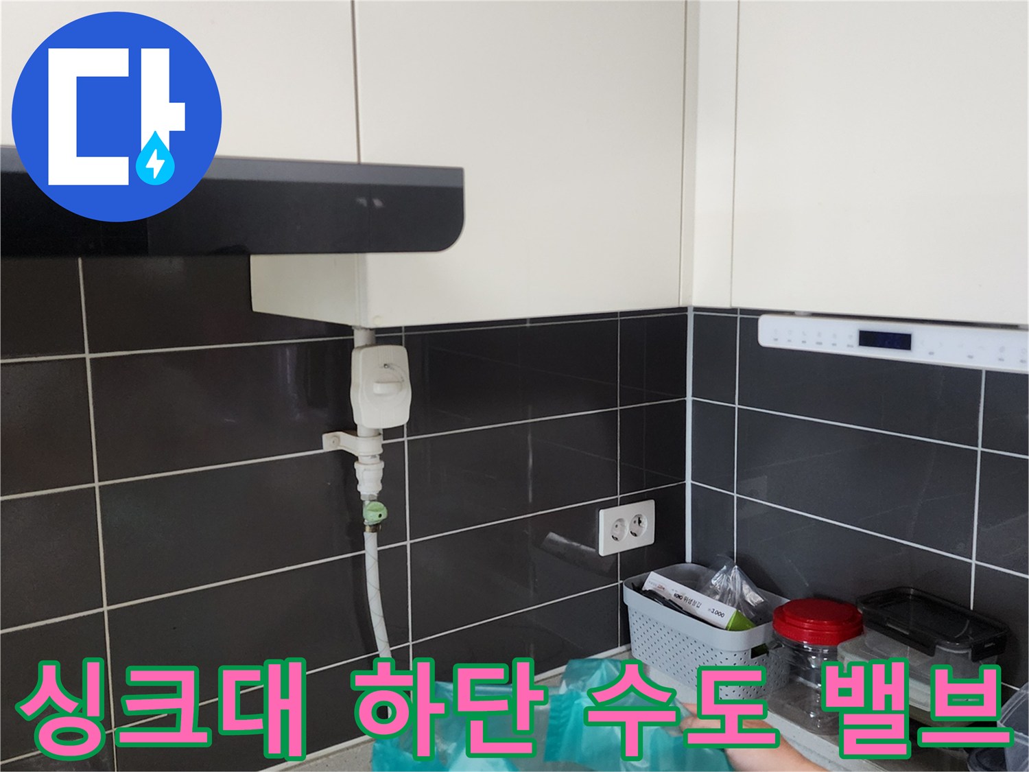 하부장 내부 벽면 타일에 설치된 급수 밸브와 연결 배관