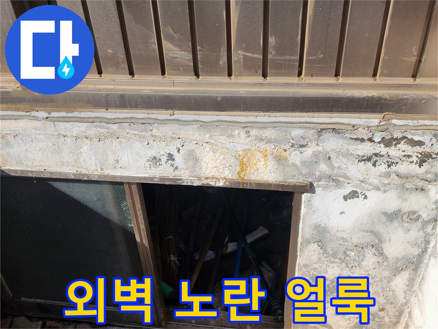 건물 외벽 하단부에 나타난 황색 얼룩과 습기 현상