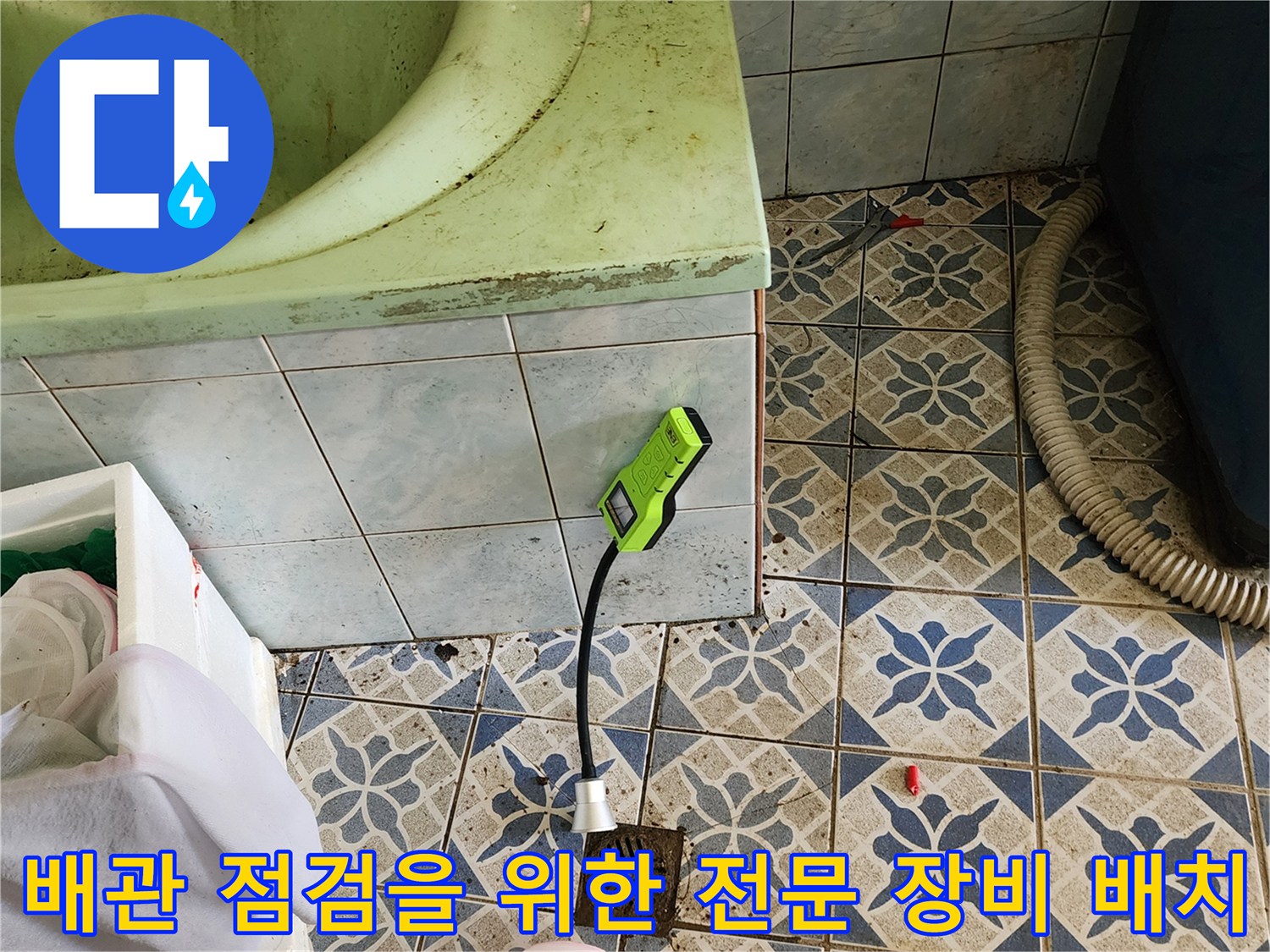욕실 바닥 타일 위 가스 탐지기와 작업 도구들이 놓여 있는 현장 상황
