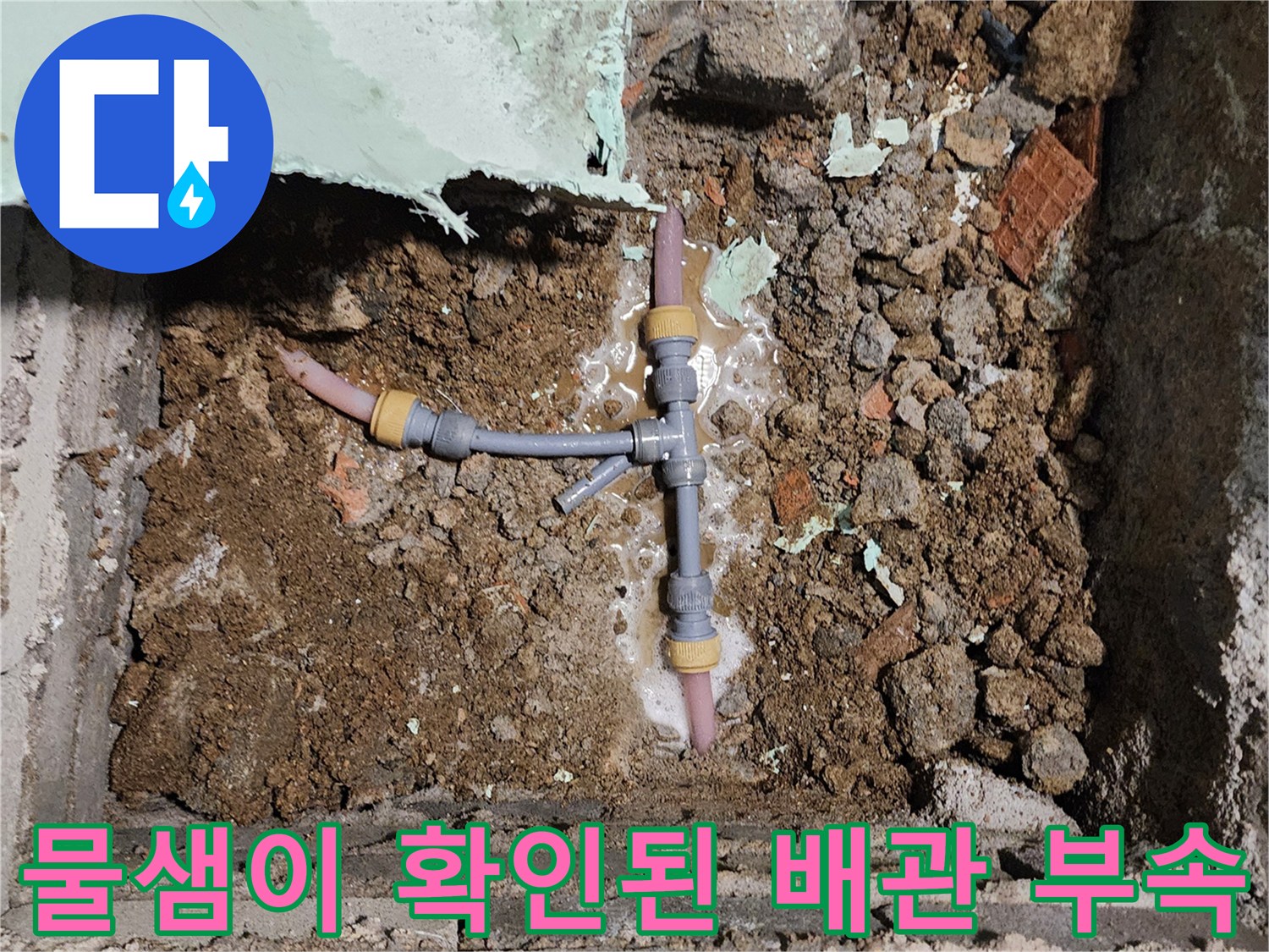흙과 시멘트 사이 드러난 젖은 배관 연결부