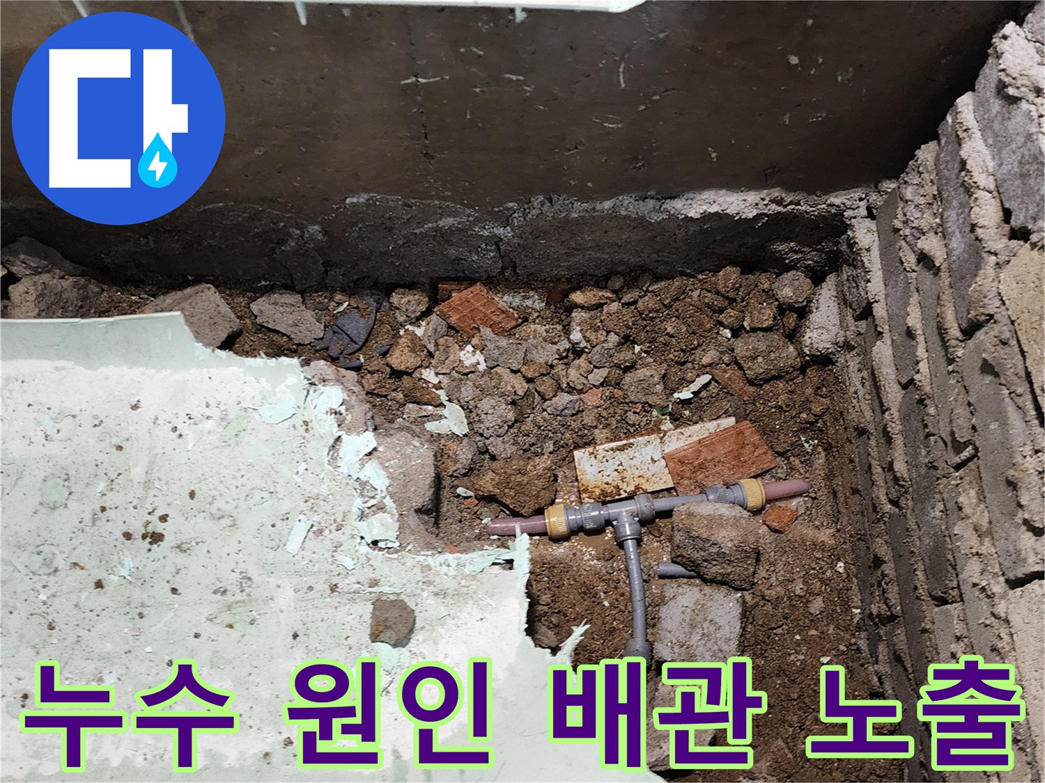 흙더미 속에 노출된-균열이 발생한 수도 배관 분기점 부위