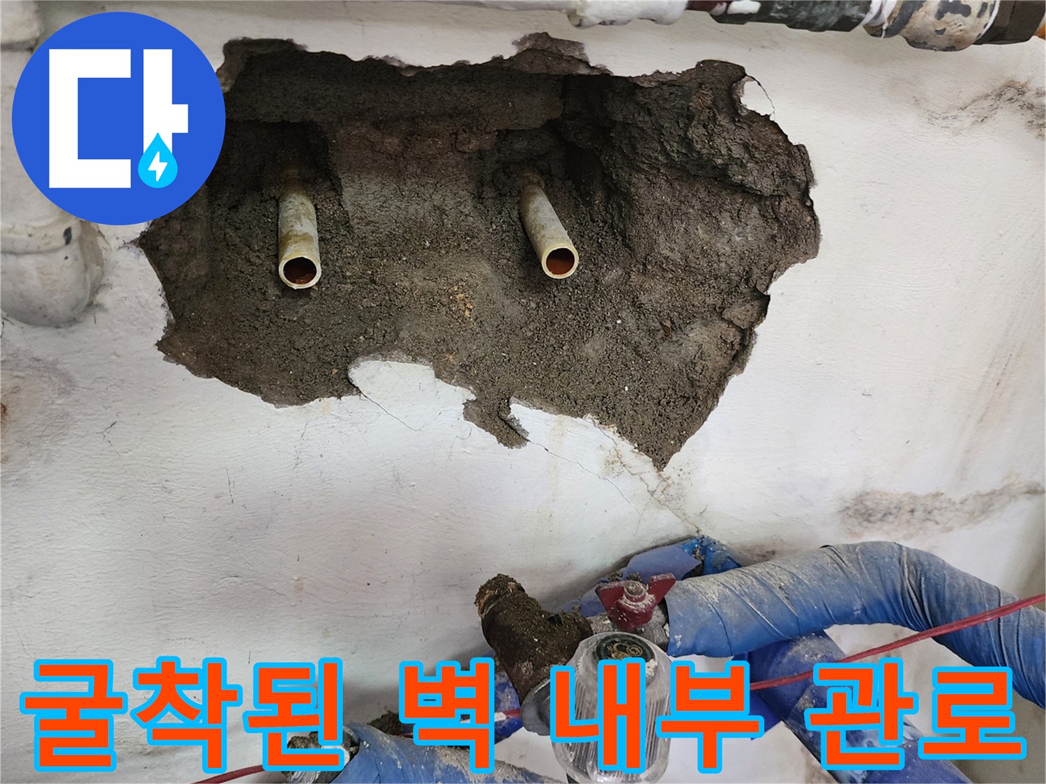 벽면 굴착 후 노출된 금속 재질의 매립형 급수 배관과 주변 환경