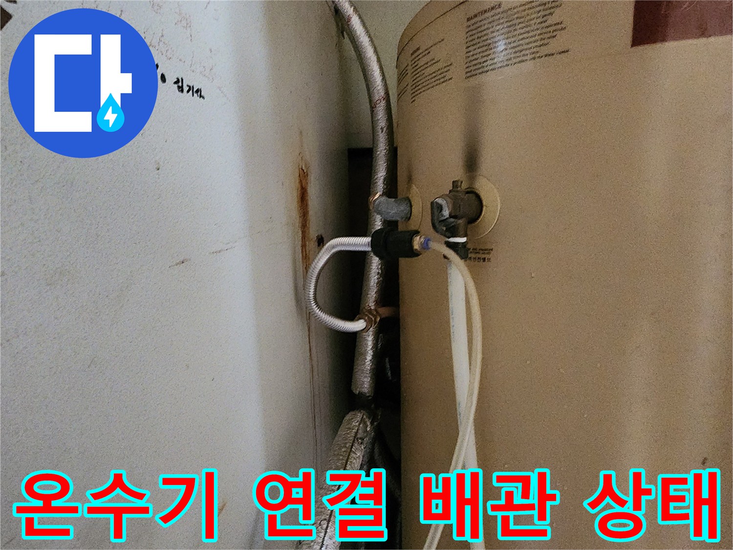 온수기 하단-금속 보온재로 감싸진 배관의 연결 부위 모습