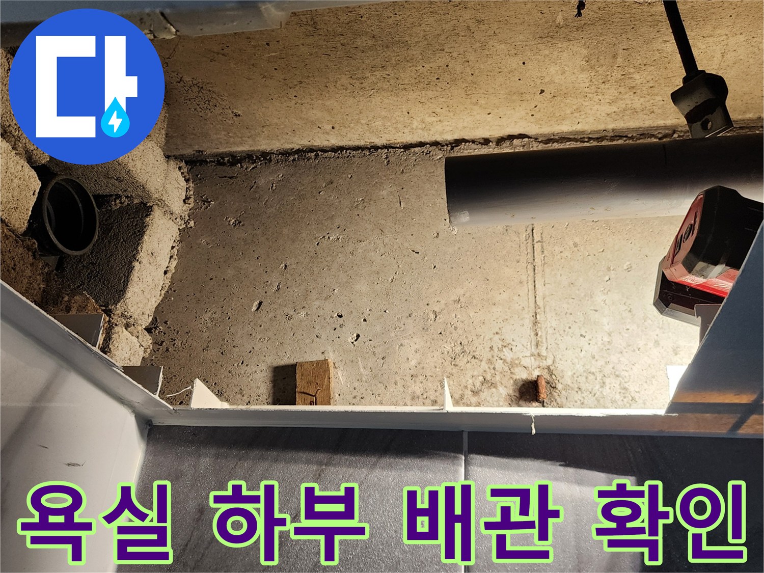 점검구 내부의 노출된 배관과 거친 콘크리트 벽면의 모습