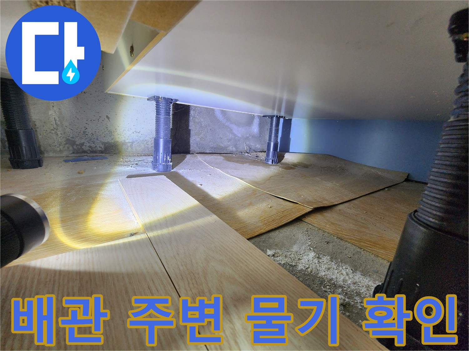 싱크대 하부장 내부의 젖은 바닥과 배관 모습 - 누수 탐지 과정