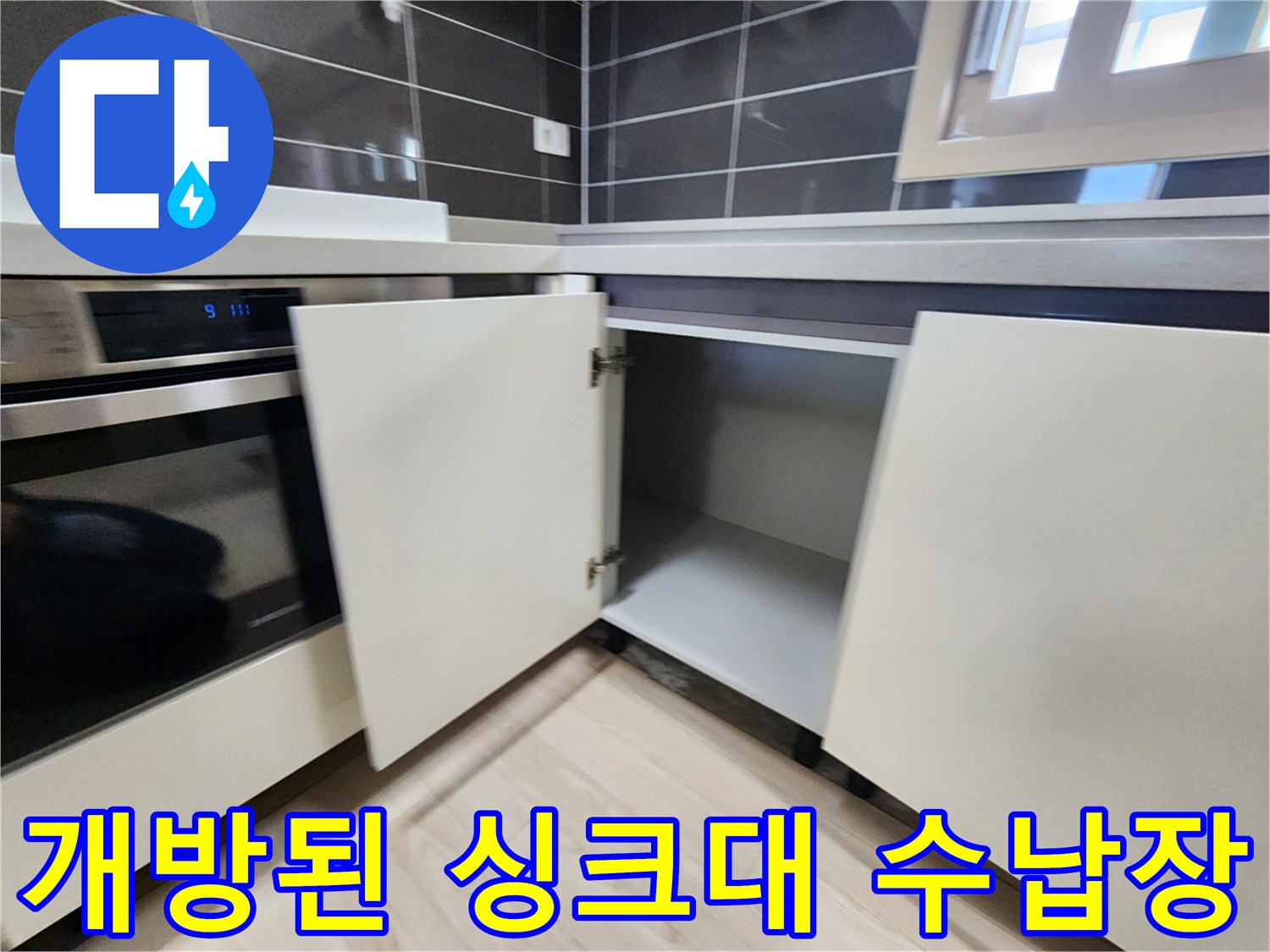 싱크대 하부장 문을 열고 배관 주변의 습기를 확인하는 사진