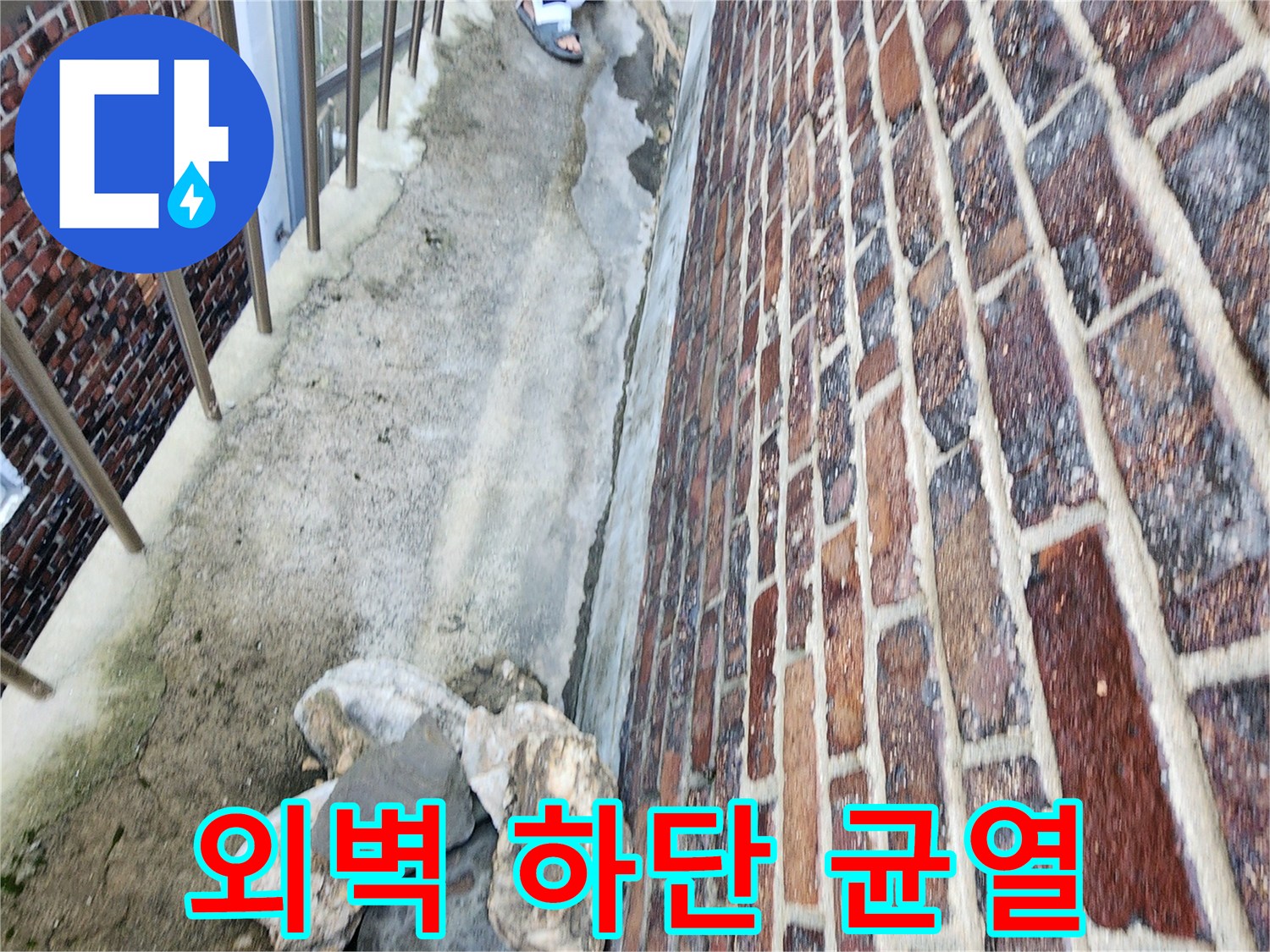 건물 외벽 벽돌 아래쪽의 벌어진 틈과 노후된 마감 상태