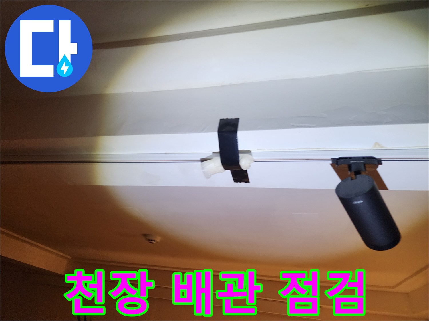 천장 내부의 배관과 연결 부위를 점검하는 모습
