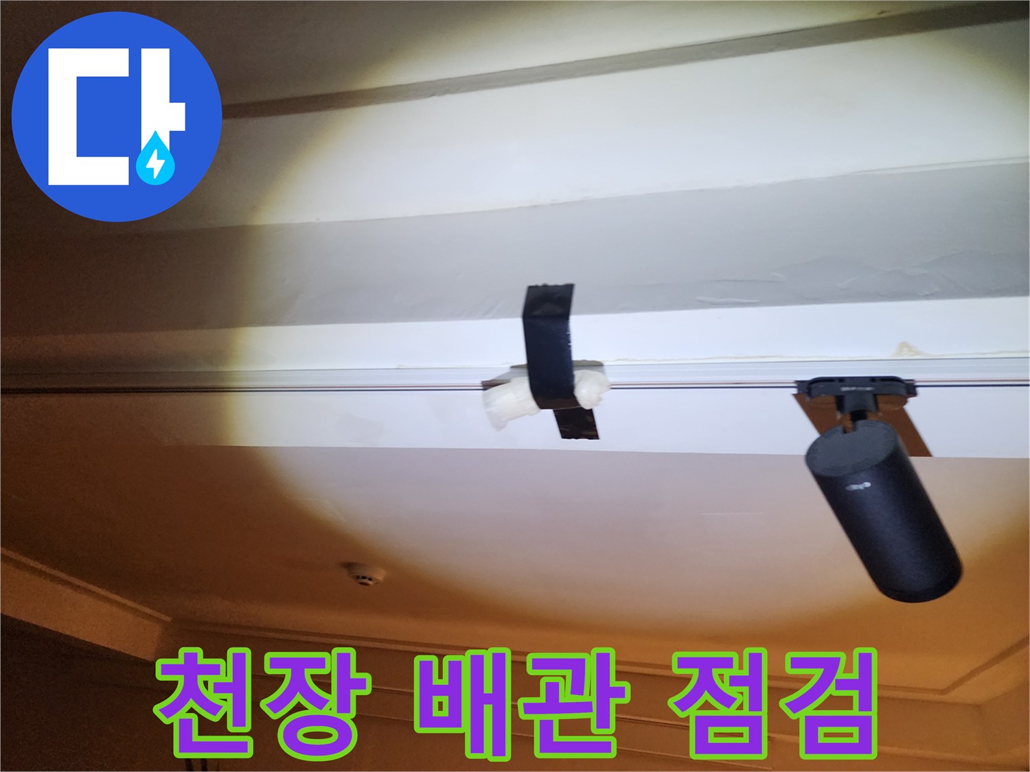 천장 내부의 배관과 연결 부위를 점검하는 모습