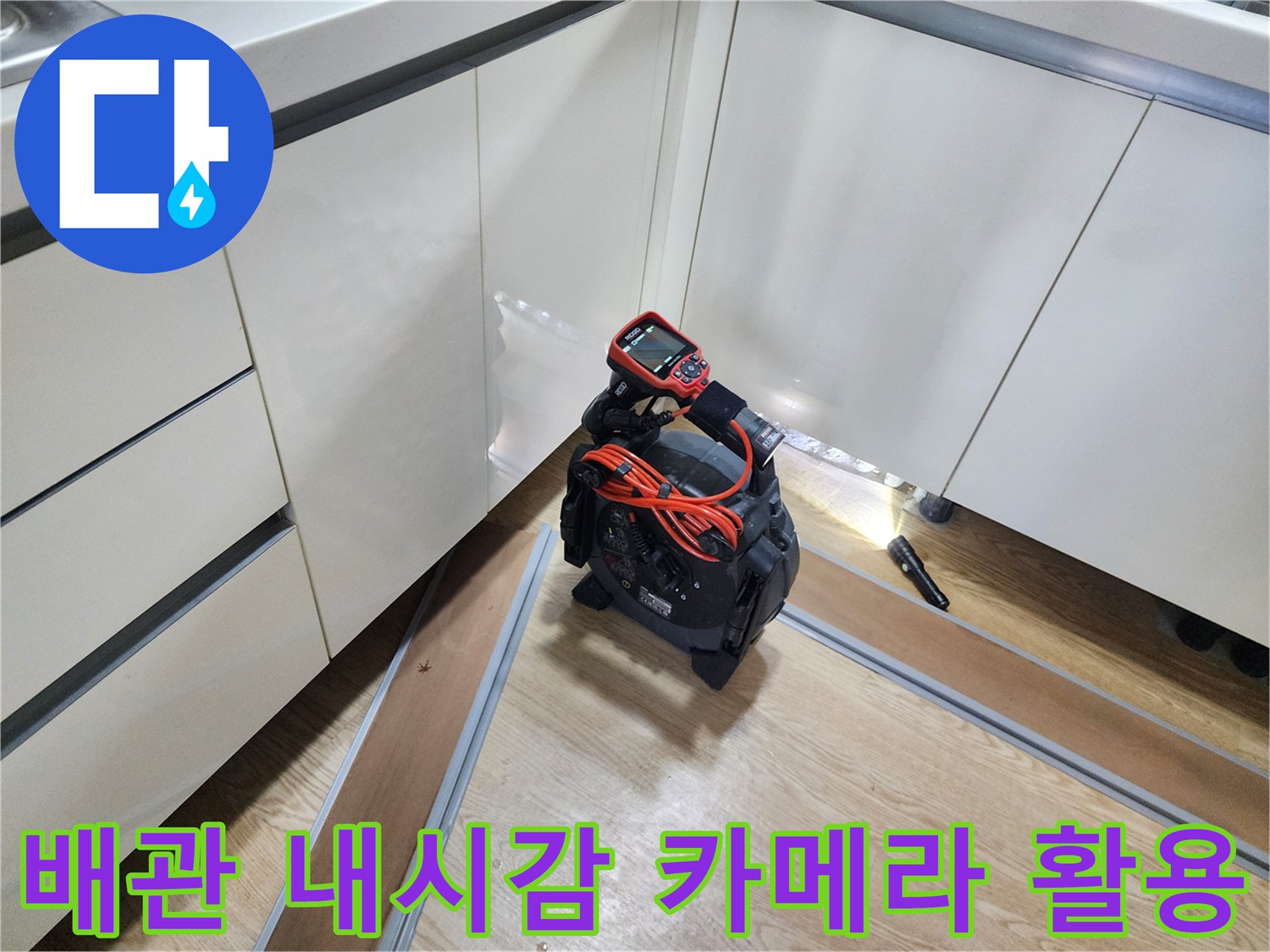 내시경 카메라 화면을 통해 싱크대 하부 배관의 결함을 확인하는 작업 중