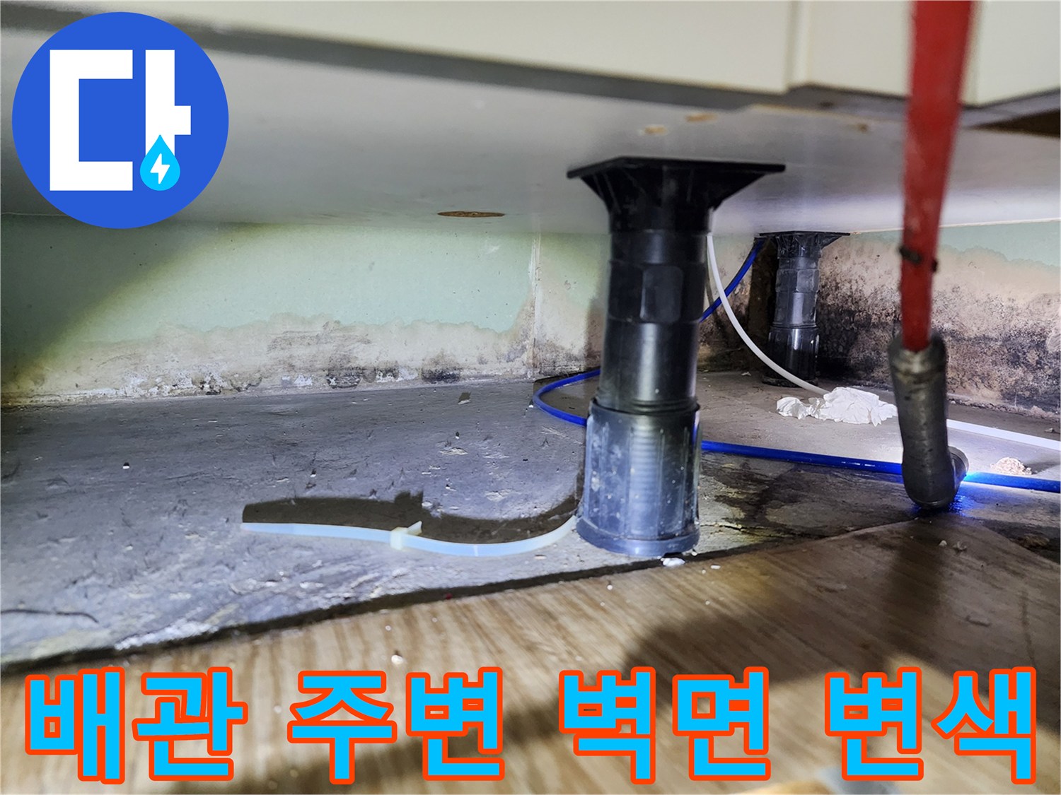 물샘으로 인해 어둡게 변한 싱크대 하부 벽면과 배관 구조