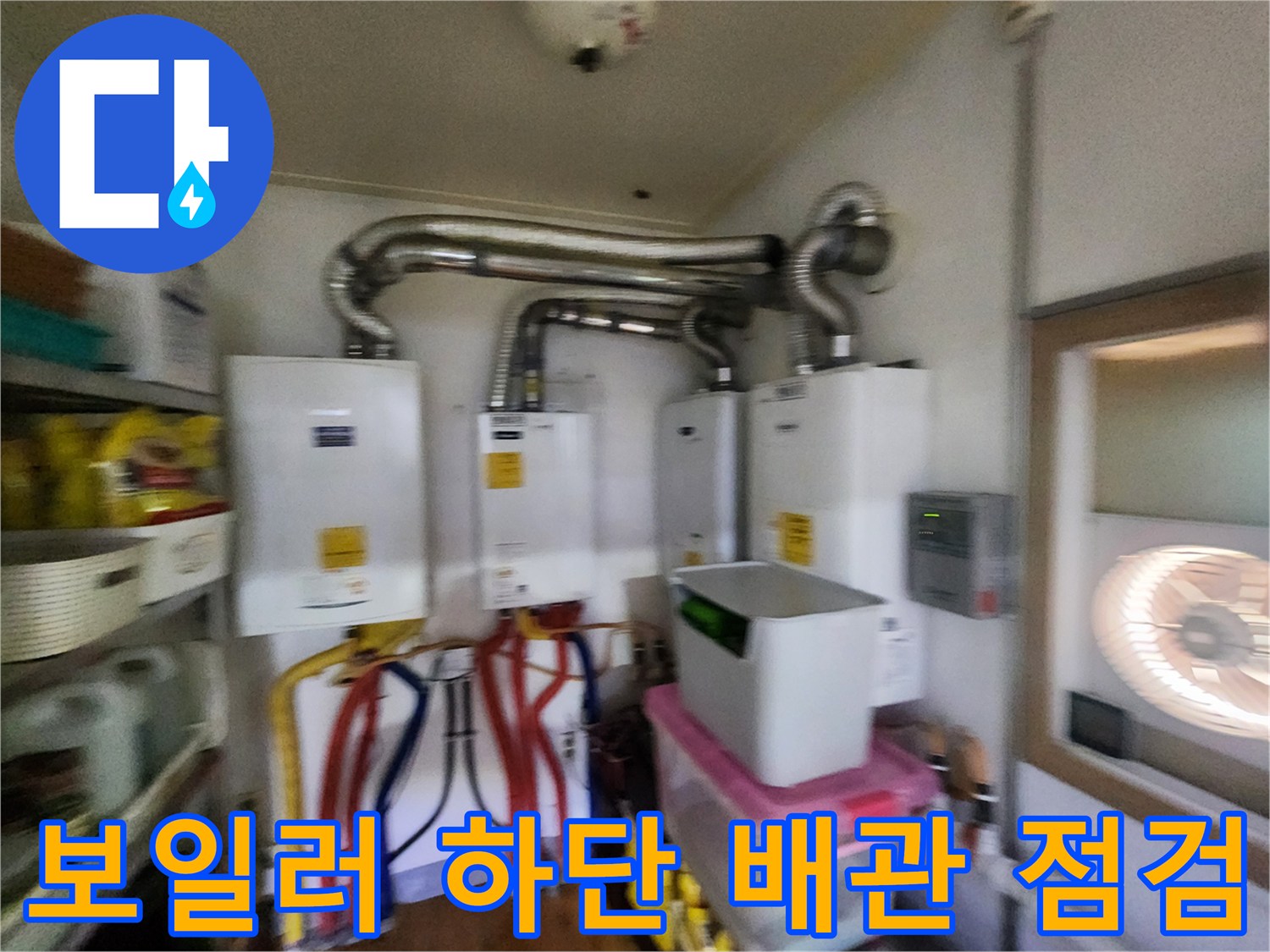 보일러 본체 아래 연결된 다양한 색상의 배관과 연통 모습