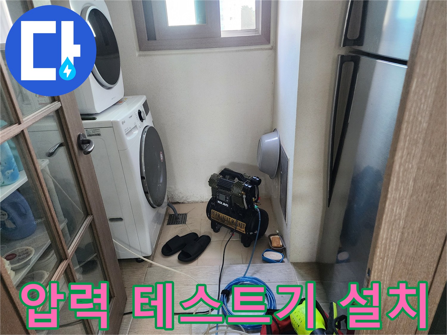 세탁기와 냉장고 사이-누수 탐지를 위해 가동 중인 에어 컴프레셔