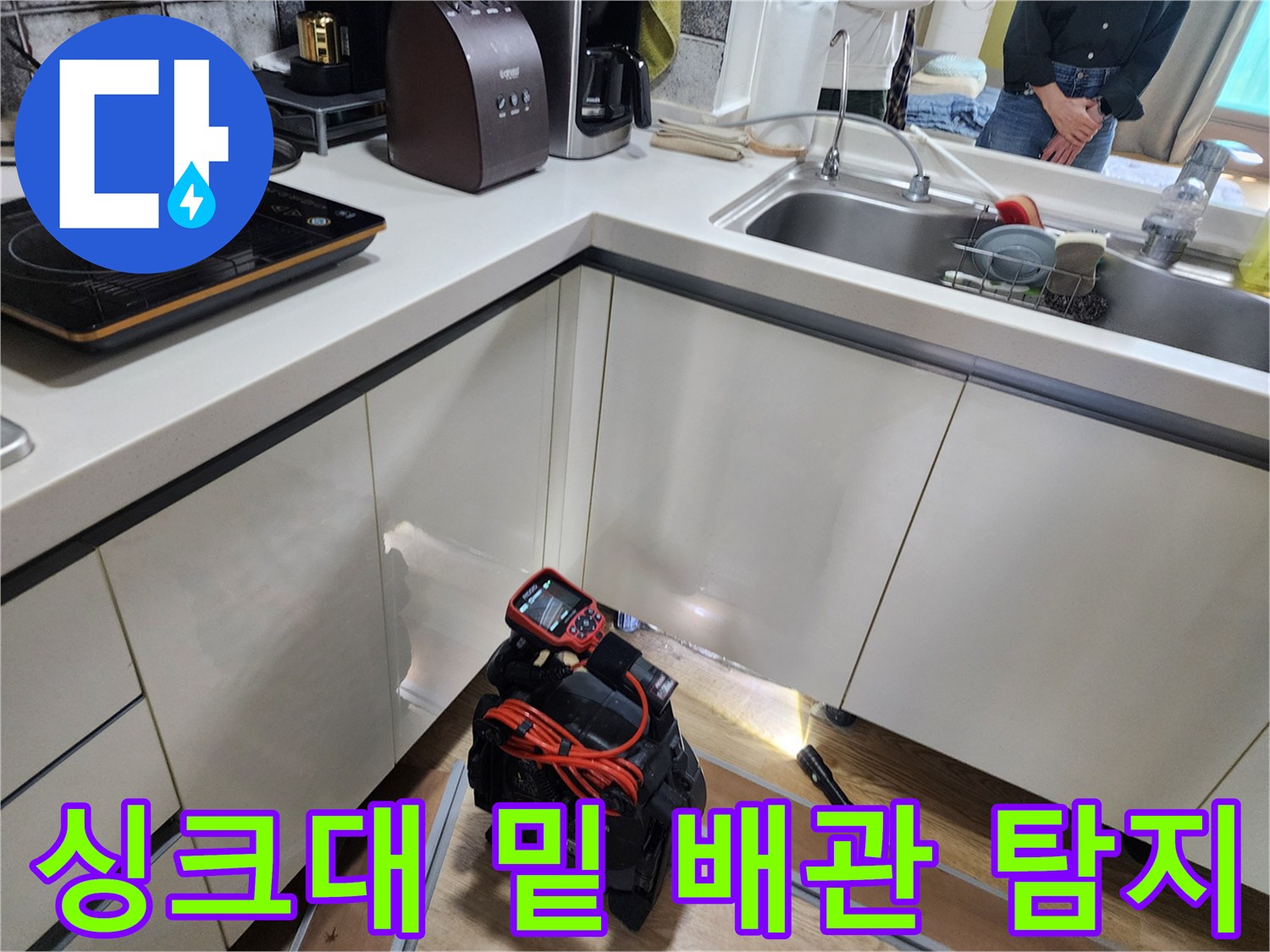 주방 싱크대 아래 공간의 배관 상태를 확인하기 위한 전문 장비 세팅 모습입니다.